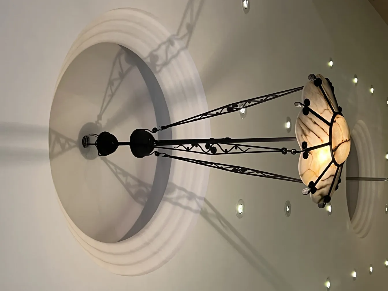 Lampada a sospensione antica che proietta un'ombra di luce soffusa in un ambiente accogliente.