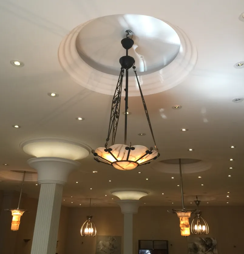 Lâmpada de teto antiga com luz quente, em um ambiente elegante.