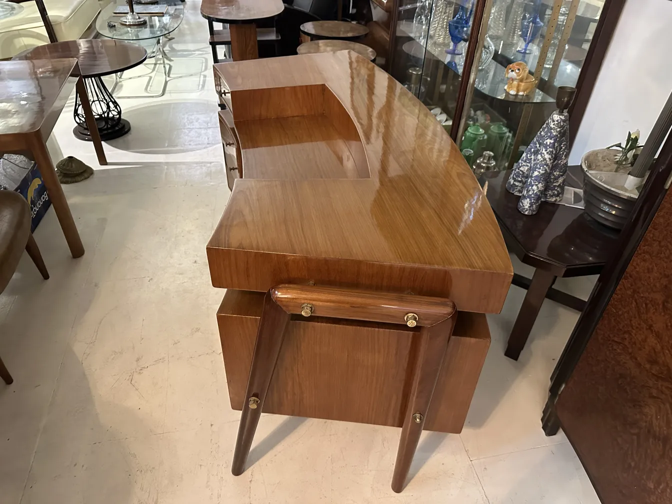 Bureau ancien en bois avec un design incurvé et des pieds élégants, entouré d'autres meubles