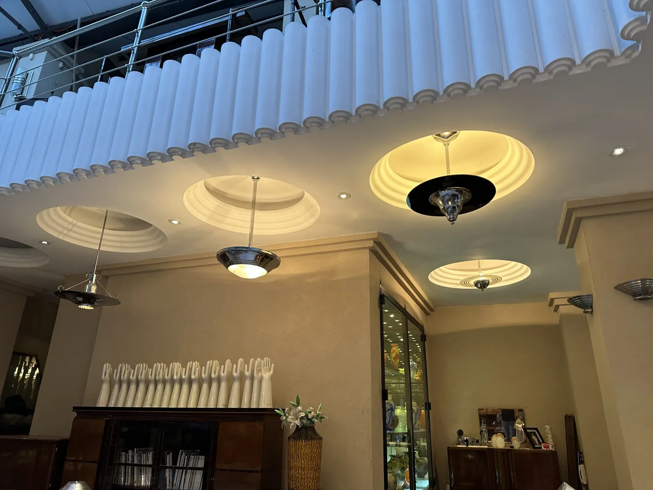 Lampada a sospensione antica con design ornamentali in un ambiente decorativo.