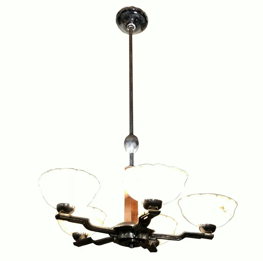 Lustre ancien avec abat-jours décoratifs dans un cadre élégant.