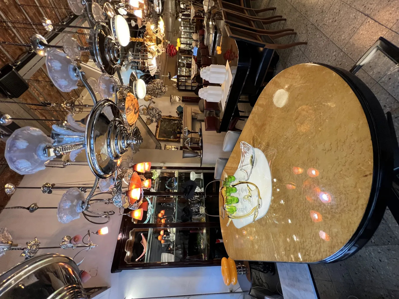 Lustre ancien avec des détails élaborés dans un cadre élégant, accompagné d'une table brillante.