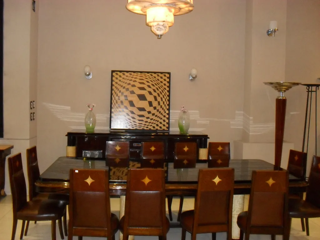 Lampada a sospensione antica che illumina una sala elegante con mobili.