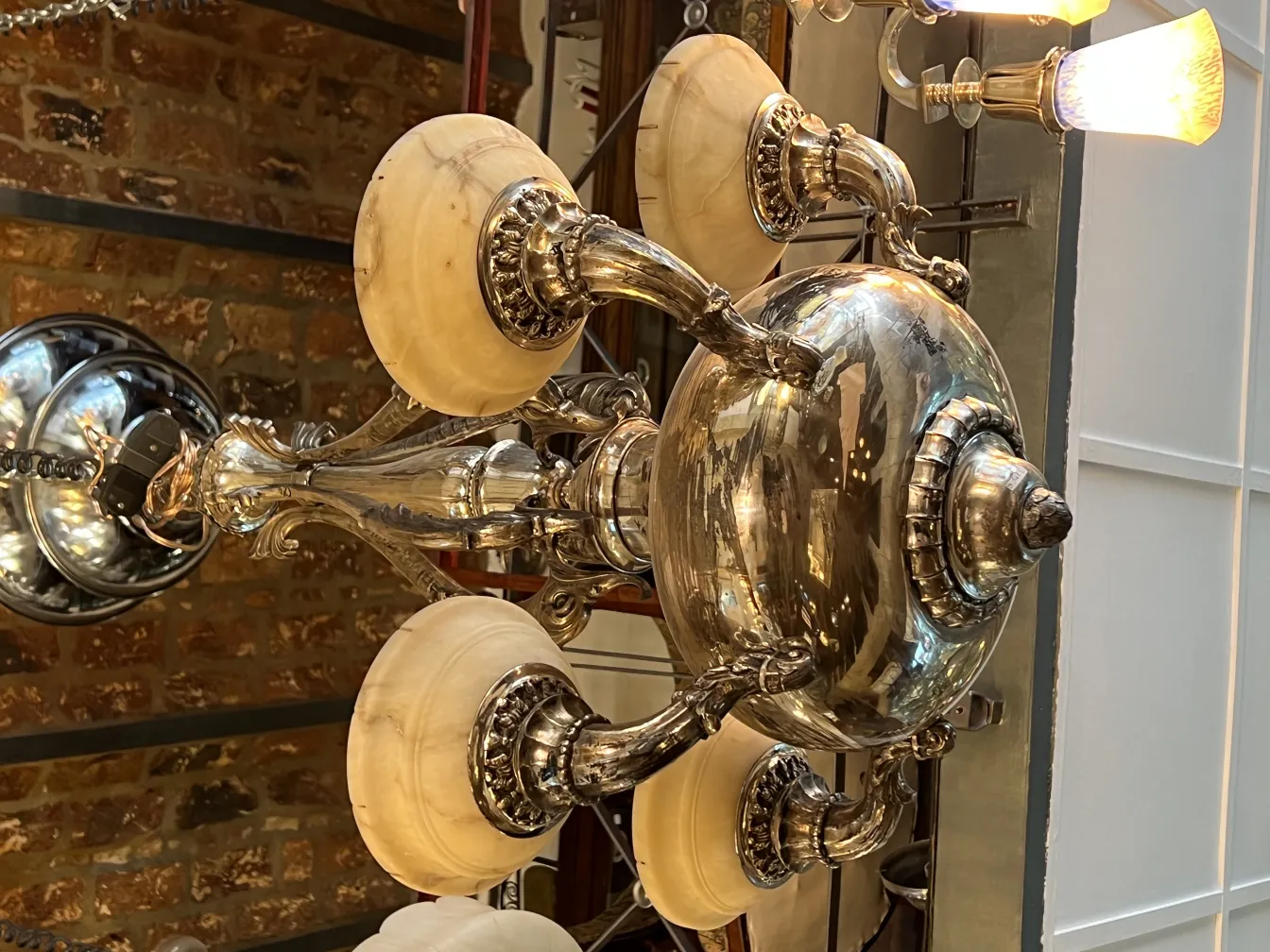 Lâmpada de teto antiga com detalhes decorativos e luzes brilhantes, ambiente elegante.