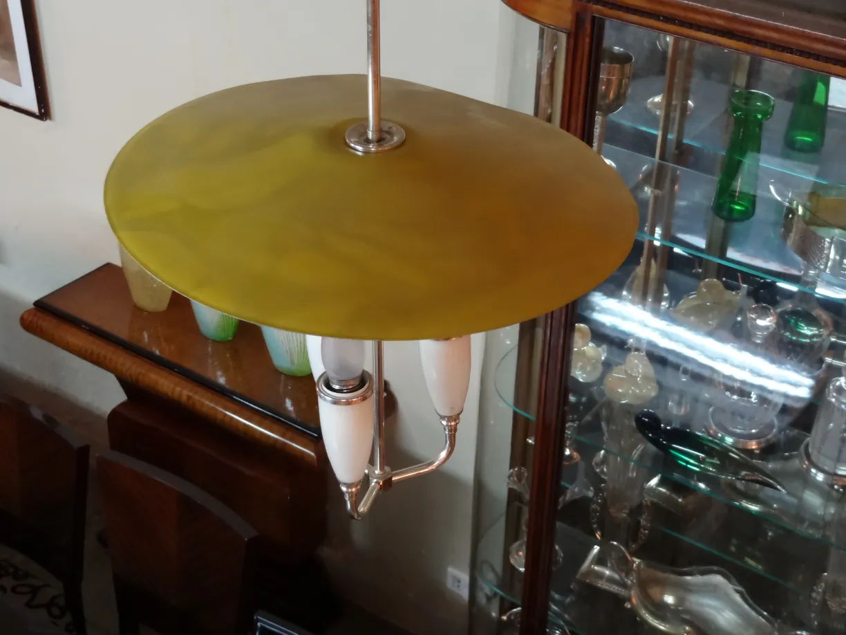 古董吊灯带黄色盘和白色臂。温馨环境与木制家具。