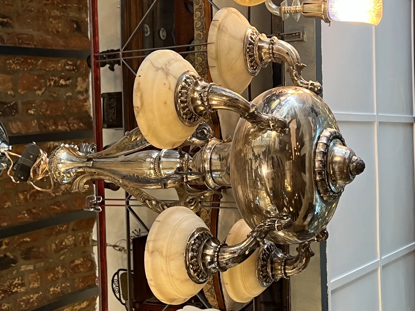 Lampada a sospensione antica con bracci decorativi e paralumi.