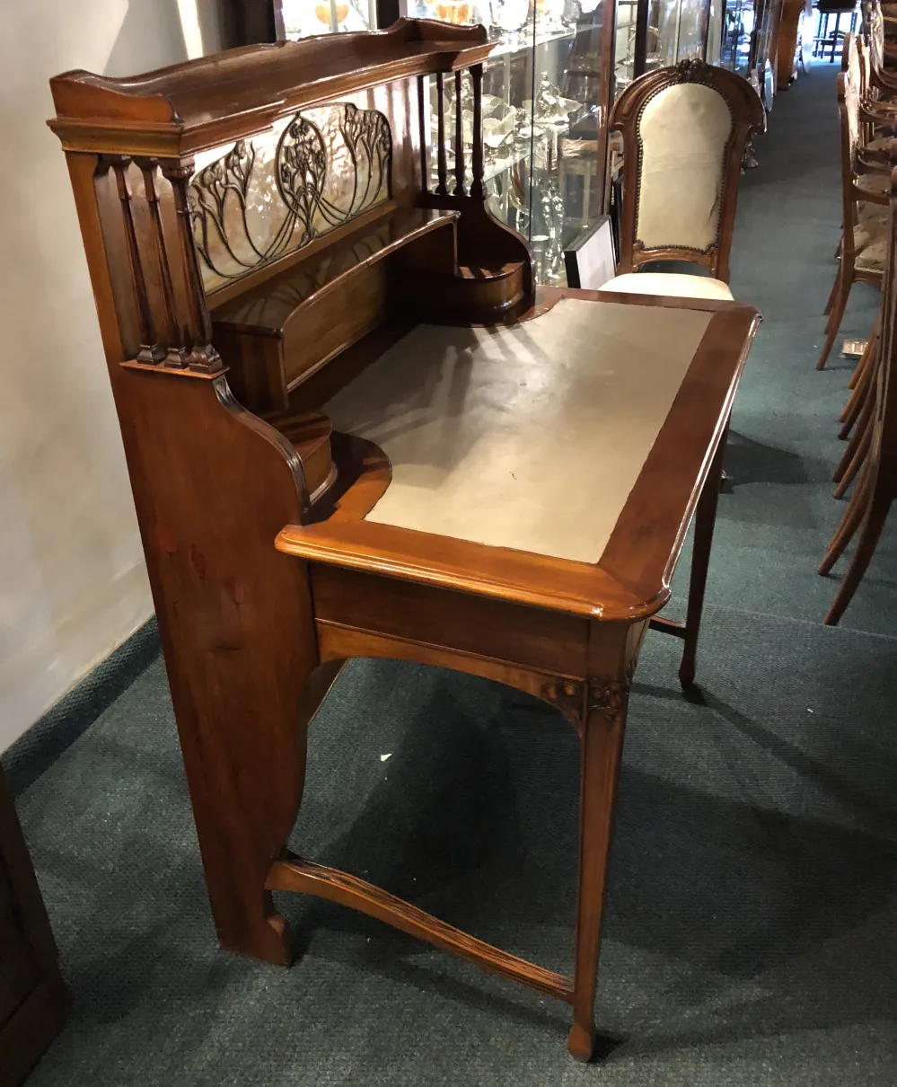 escritorio antiguo con decoración de vidrio y detalles en madera, ambiente de antigüedades