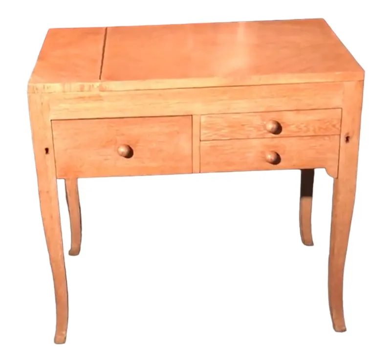 Bureau ancien en bois clair avec deux tiroirs arrondis.