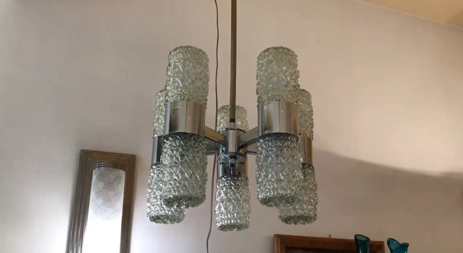 Antique hanging lamp with shiny metal structure and faceted glass shades, perfect for home lighting.