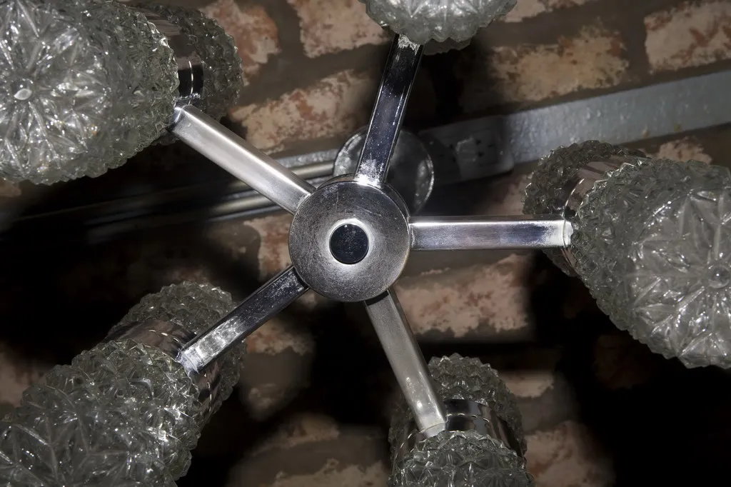 Detalles de una lámpara de techo antigua con cristal brillante en un ambiente acogedor.