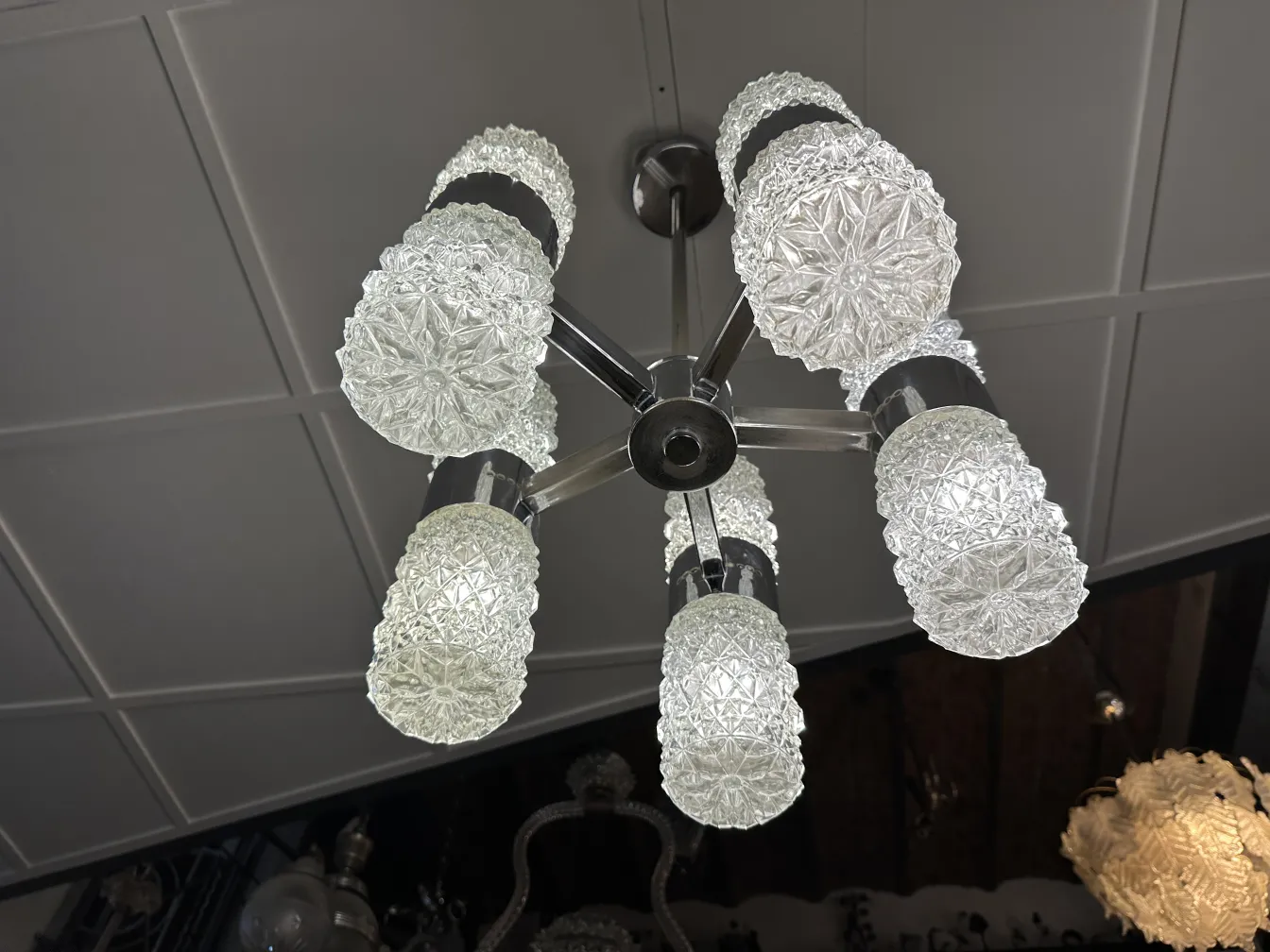 Lustre ancien avec abat-jour en verre dépoli, ambiance élégante.