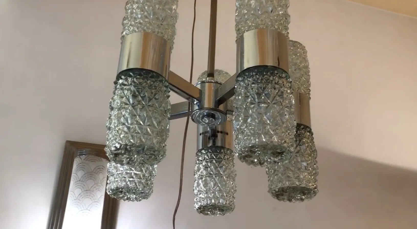 Lâmpada de teto antiga com cristais decorativos em um ambiente clássico.