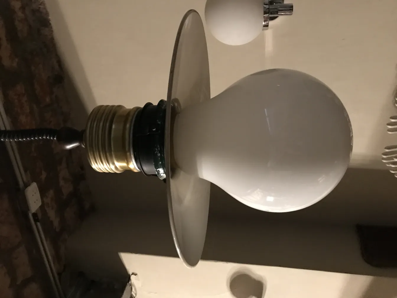 Lampada a sospensione antica con forma sferica e base elegante.