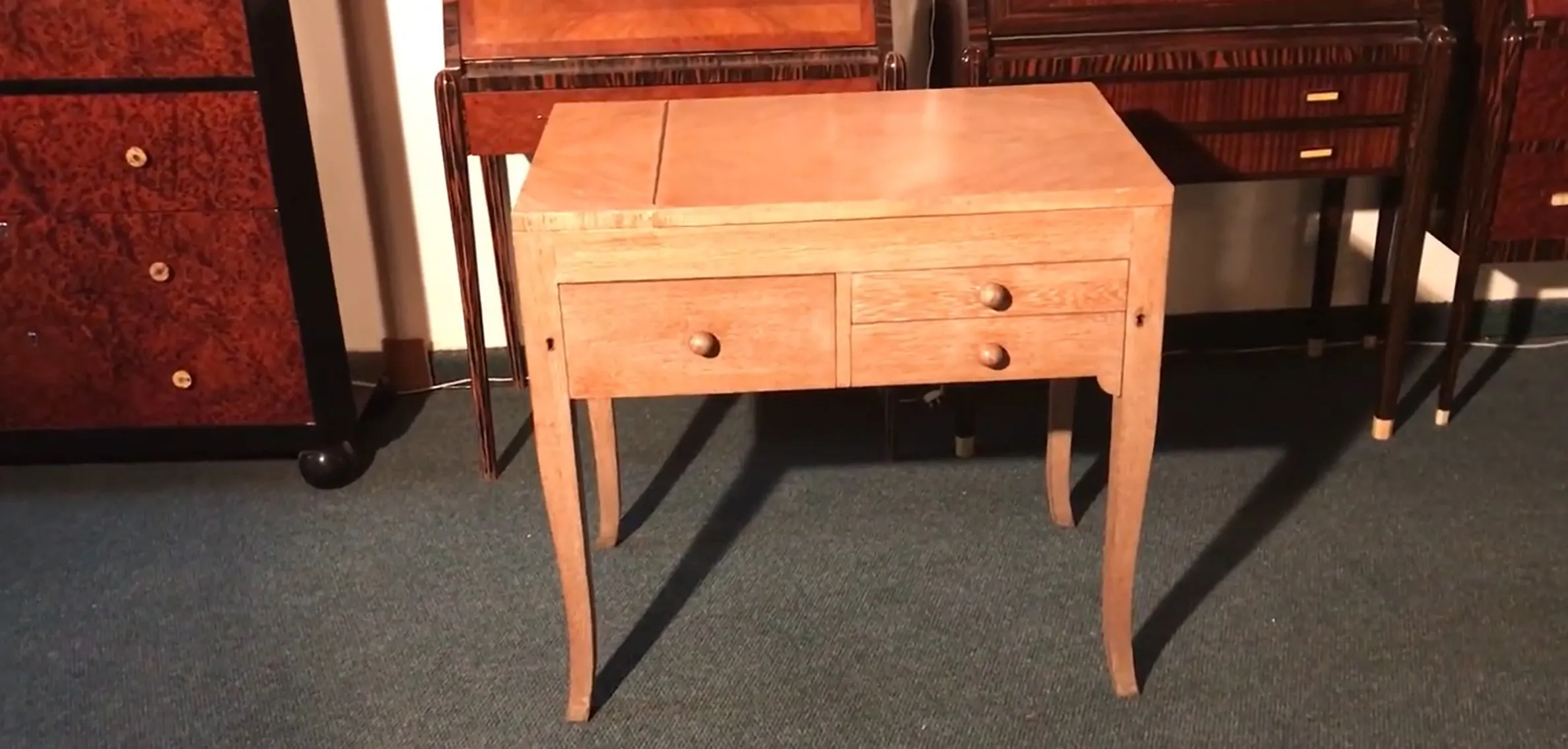 Escritorio antiguo con dos cajones de madera clara, estilo elegante.