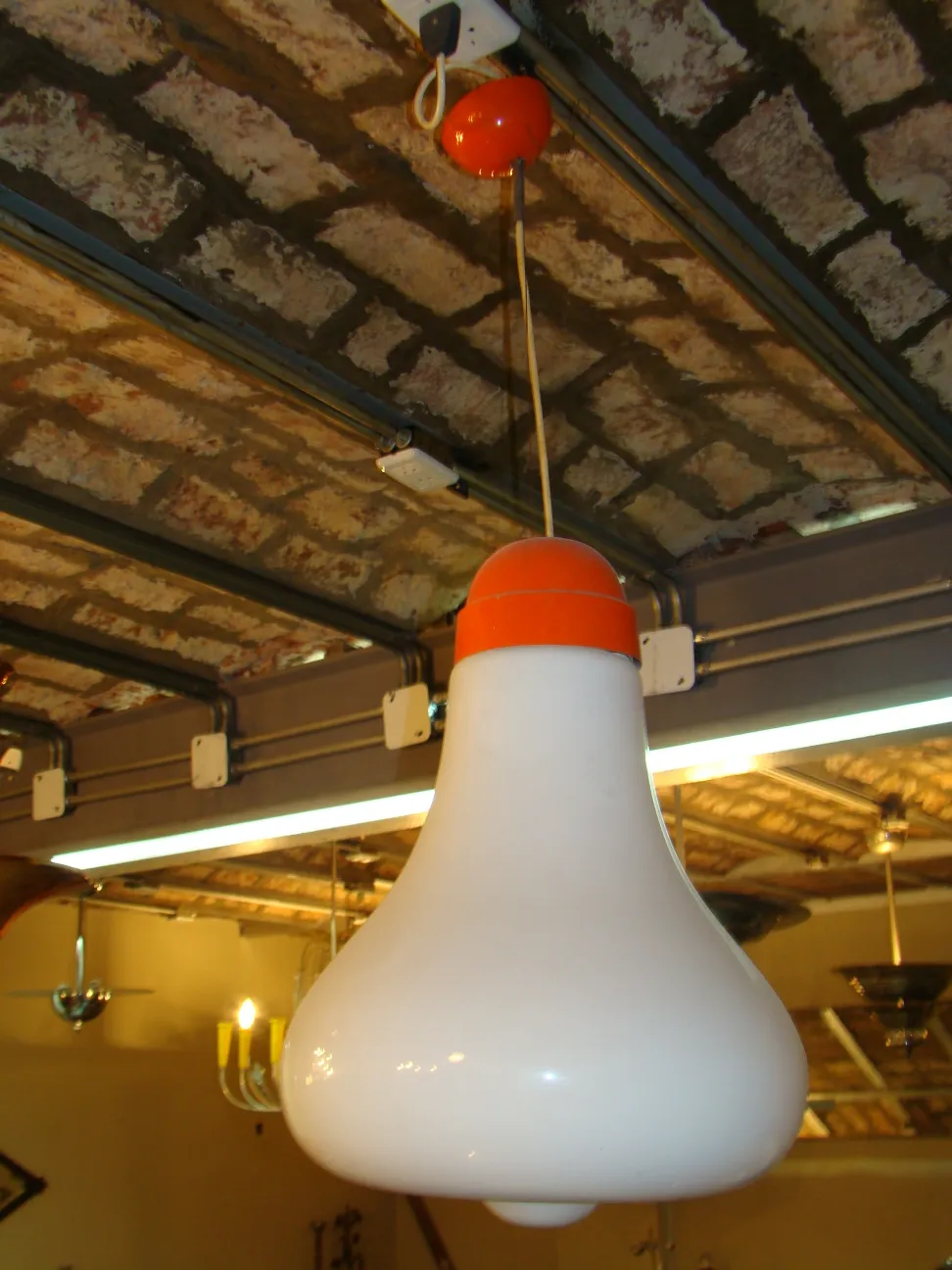 Lámpara de techo antigua blanca con detalles naranjas en ambiente rústico