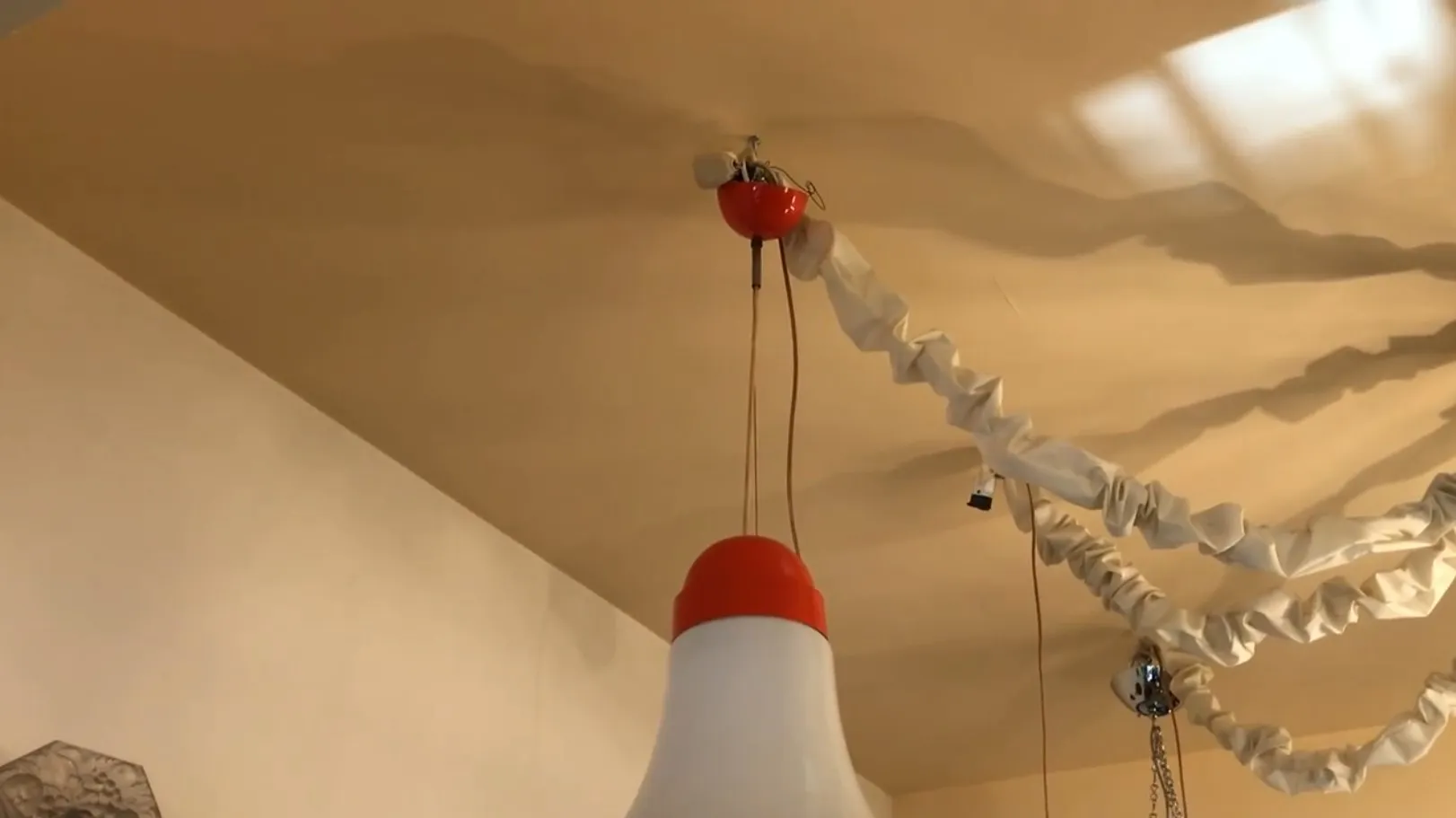 Lámpara de techo antigua con diseño rojo y blanco, en un ambiente acogedor.