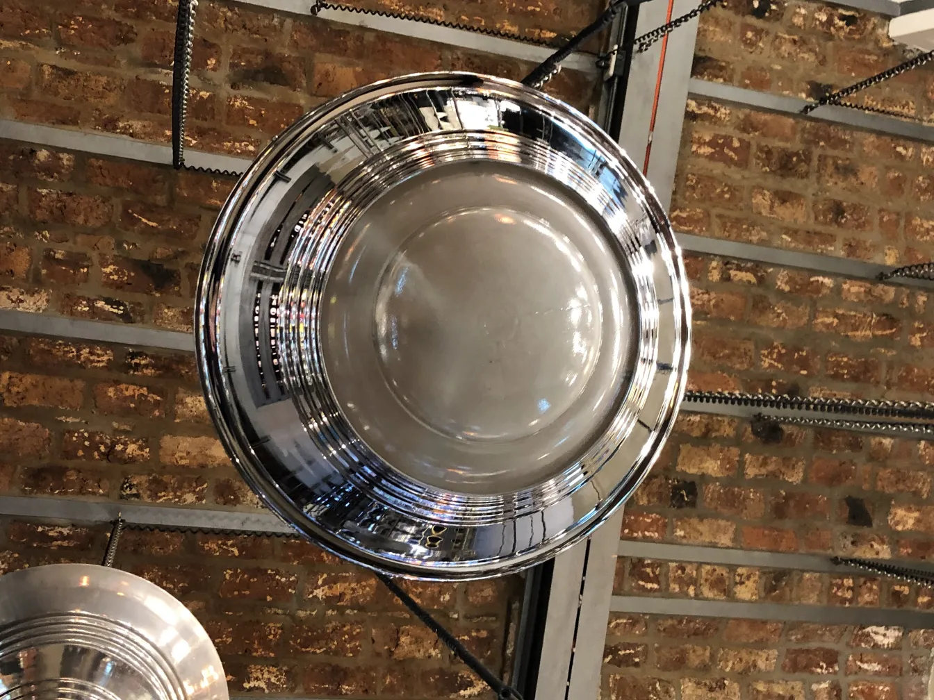 Antique hanging lamp with a bright finish, elegant design in a rustic setting.