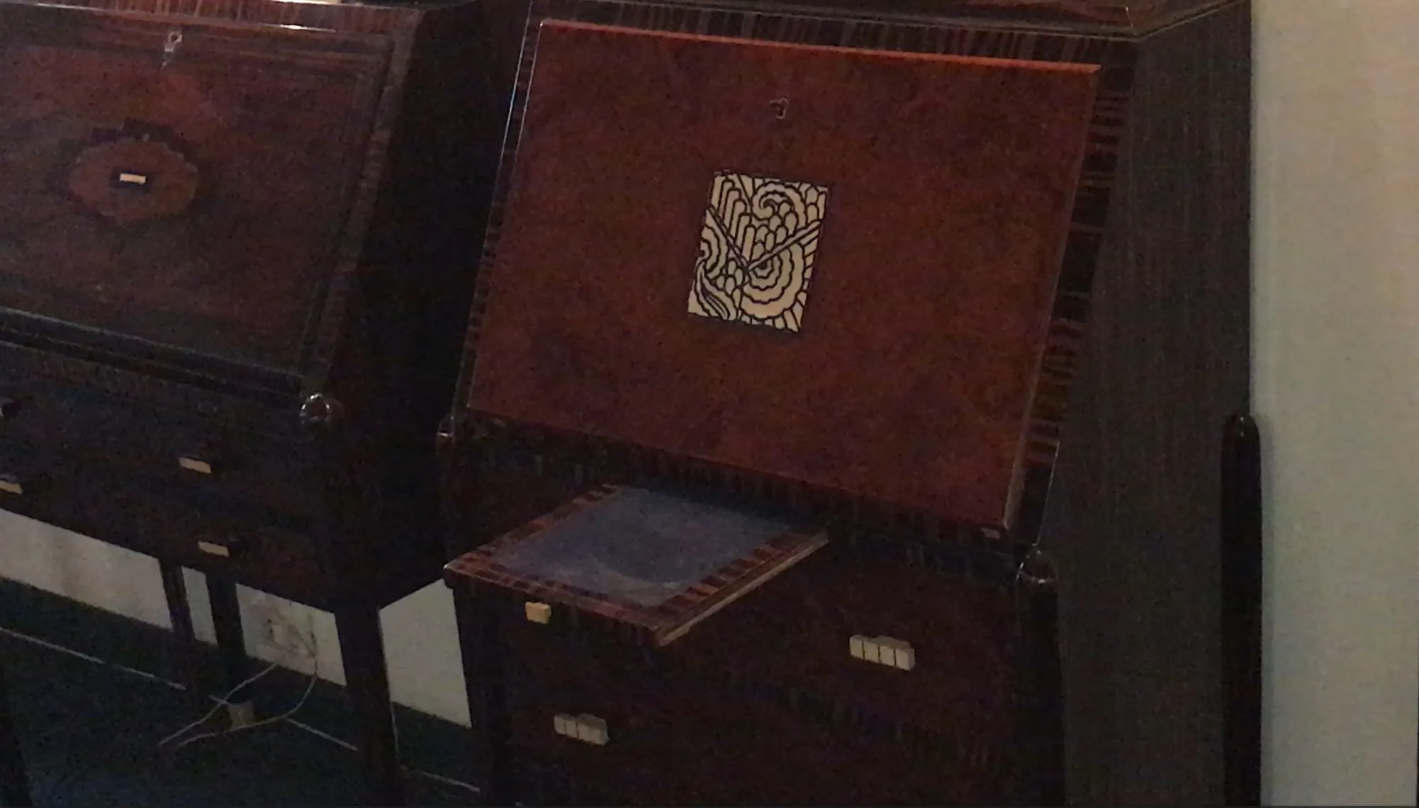 escritorio antiguo de madera con un diseño en la tapa