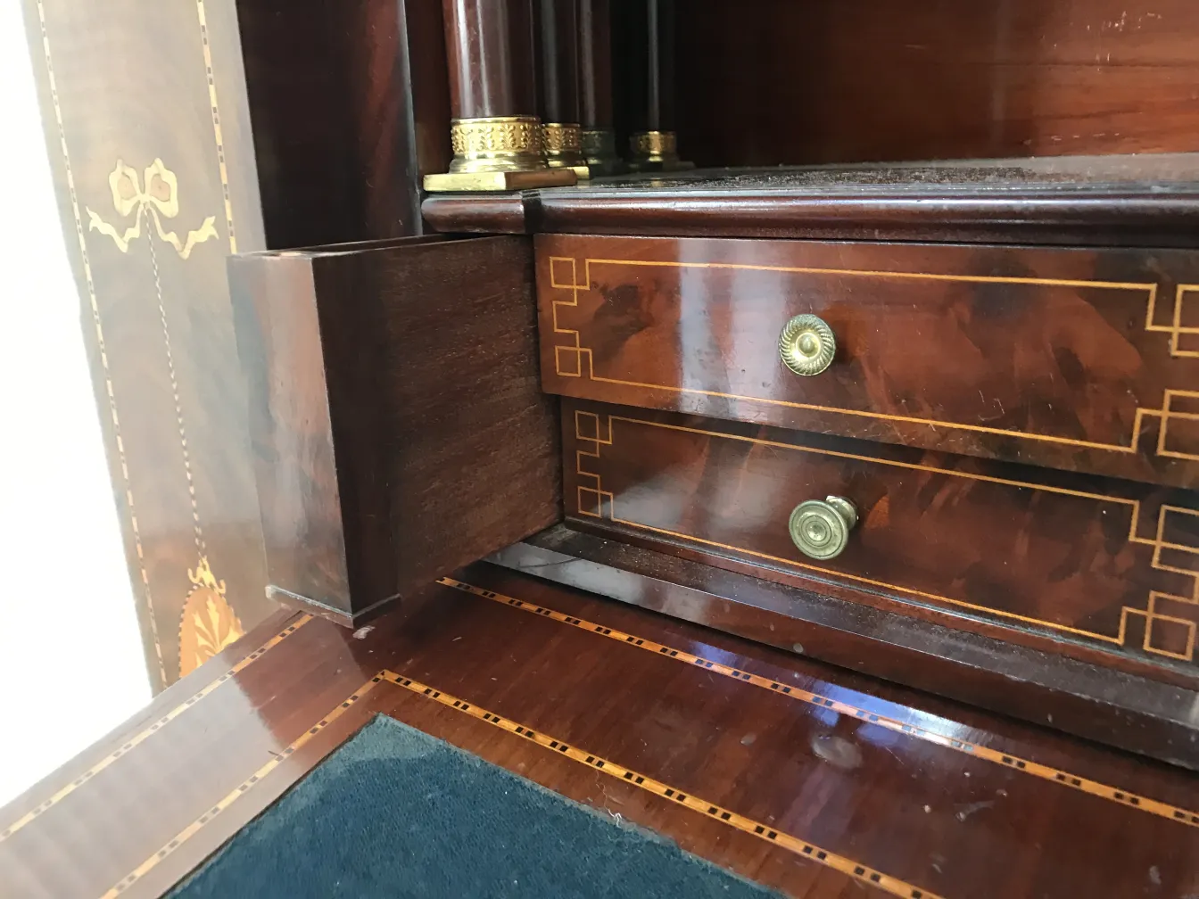 Antique desk with wooden details and two drawers.