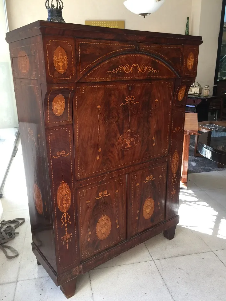 Escritorio antiguo con intrincados detalles en madera, ambiente acogedor.