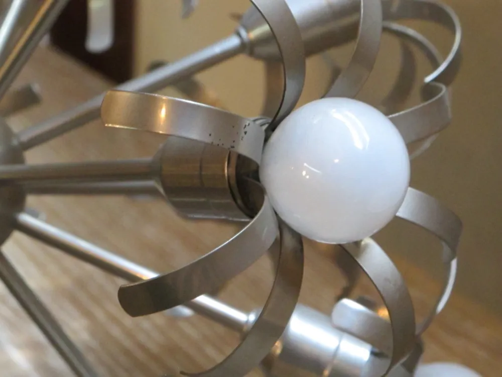 Antike Hängelampe mit weißen Kugeln und elegantem Design.