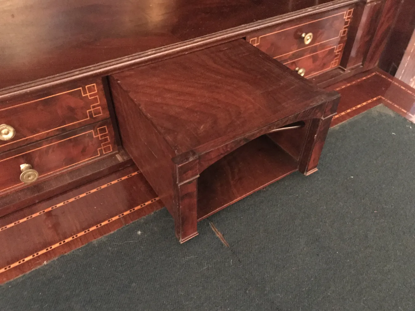 Bureau ancien avec espace de rangement en dessous, fond marron