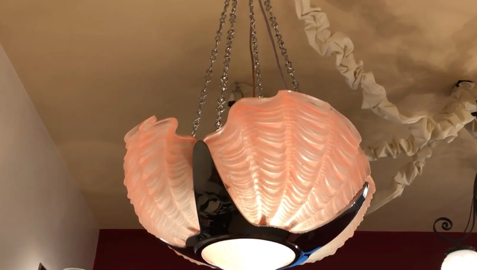 Lámpara de techo antigua de diseño en forma de concha, en un ambiente acogedor.