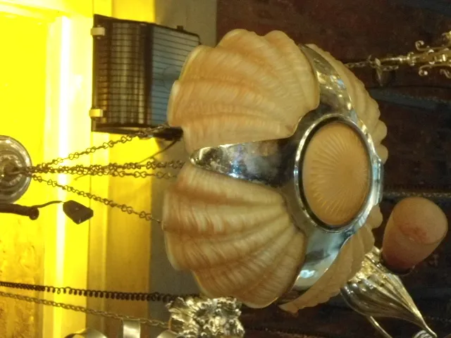 Lampada a sospensione antica con dettagli chiari e scuri in un ambiente accogliente.