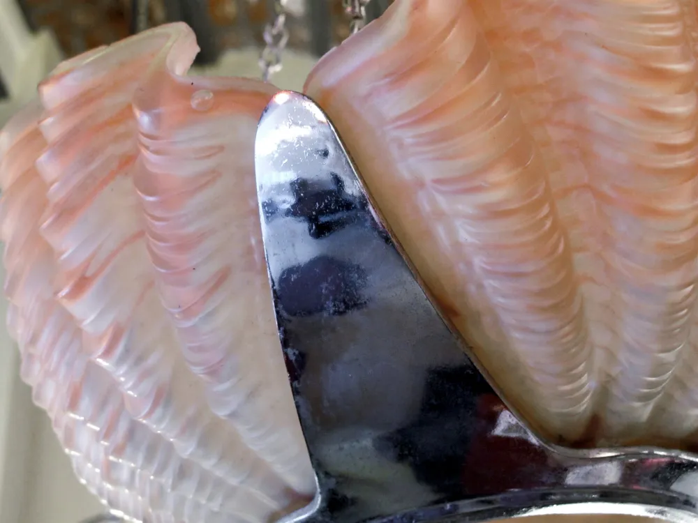 Lampada a sospensione antica con design elegante e colori chiari, ambientata in uno sfondo classico.