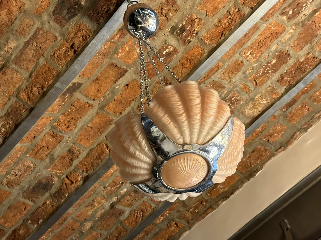 Antike Hängelampe mit klassischem Design in einem hellen, gemütlichen Raum.