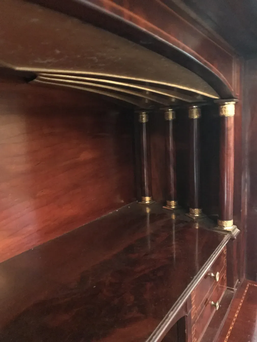 Innenansicht eines antiken Schreibtisches mit Abtrennungen und ornamentalen Details.