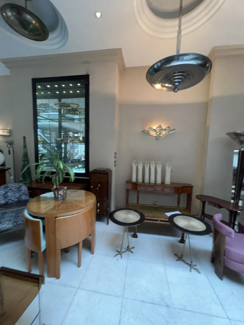 Lustre ancien suspendu dans une ambiance élégante avec des meubles en bois.