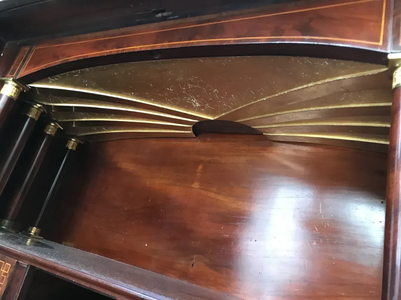 Détail d'un bureau ancien avec des finitions dorées.