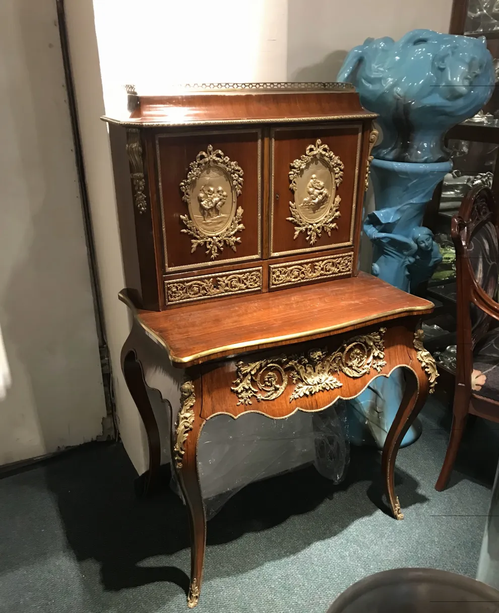 antique wooden desk with gold details and elegant legs in a classic setting