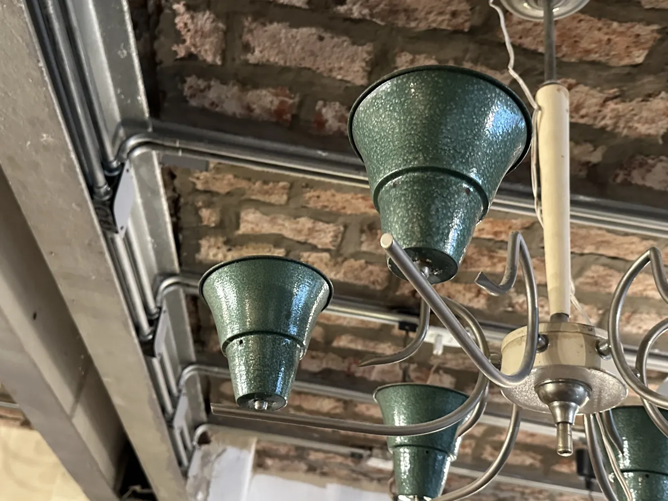 Lámpara de techo antigua con tonos verdes, estilo clásico, en un entorno moderno.