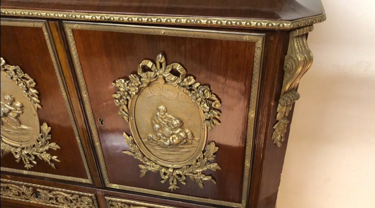Antique desk featuring fine golden relief details.