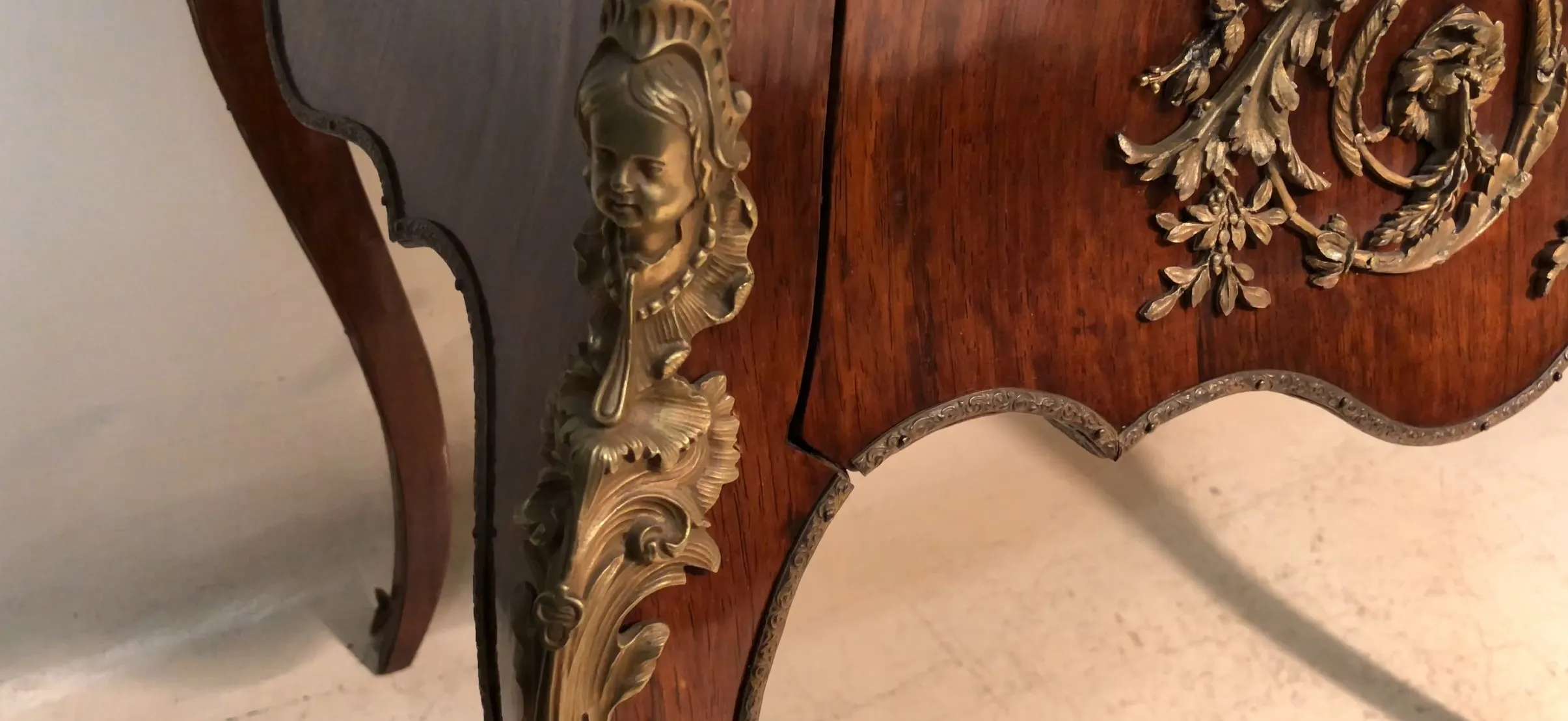 Antique desk featuring relief details and decorative legs.