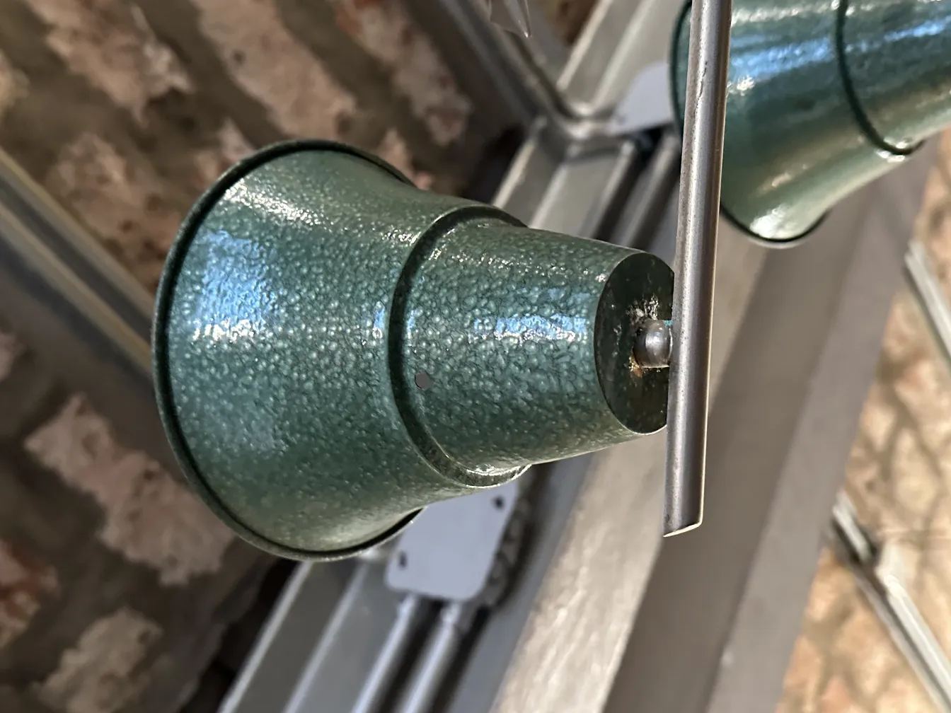 lampada a sospensione verde antica con design attraente in ambiente rustico.