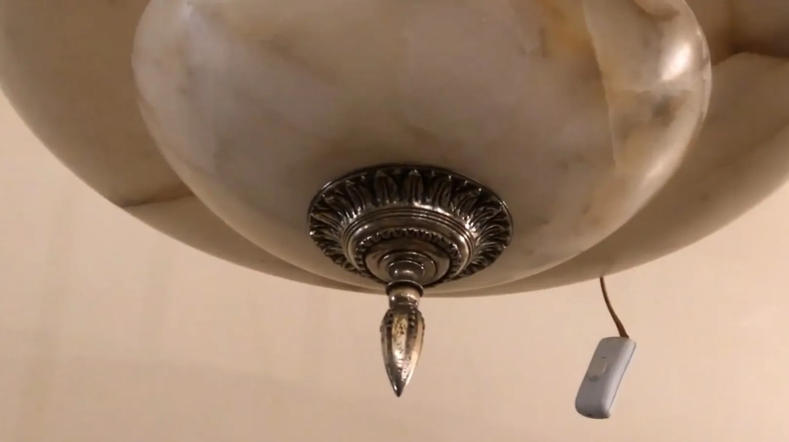 Lampada a sospensione antica con design elegante e dettagli decorativi.