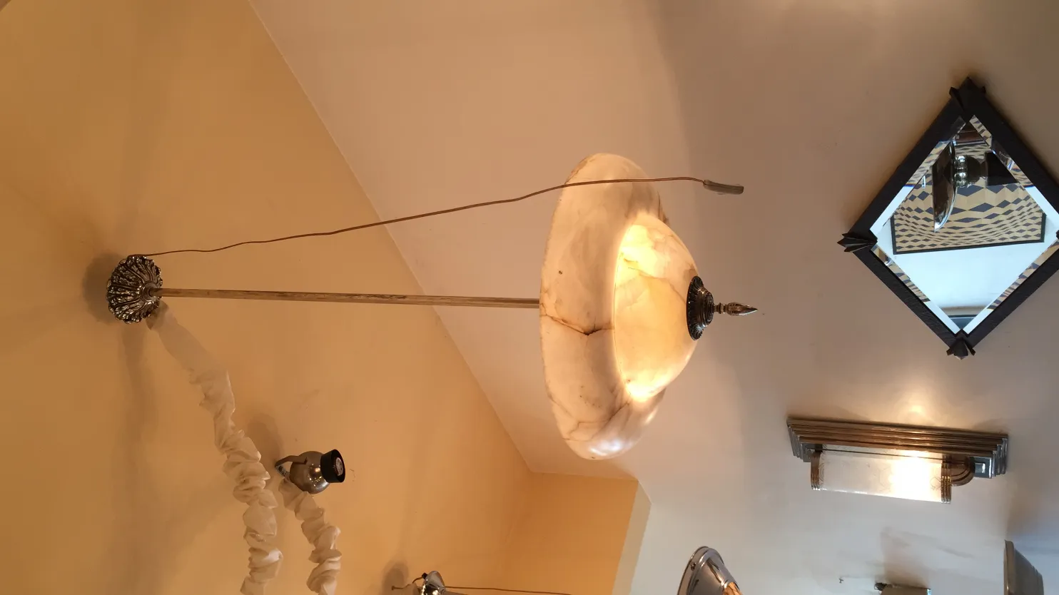 lampada a sospensione antica in alabastro, dettagli eleganti e luce soffusa.