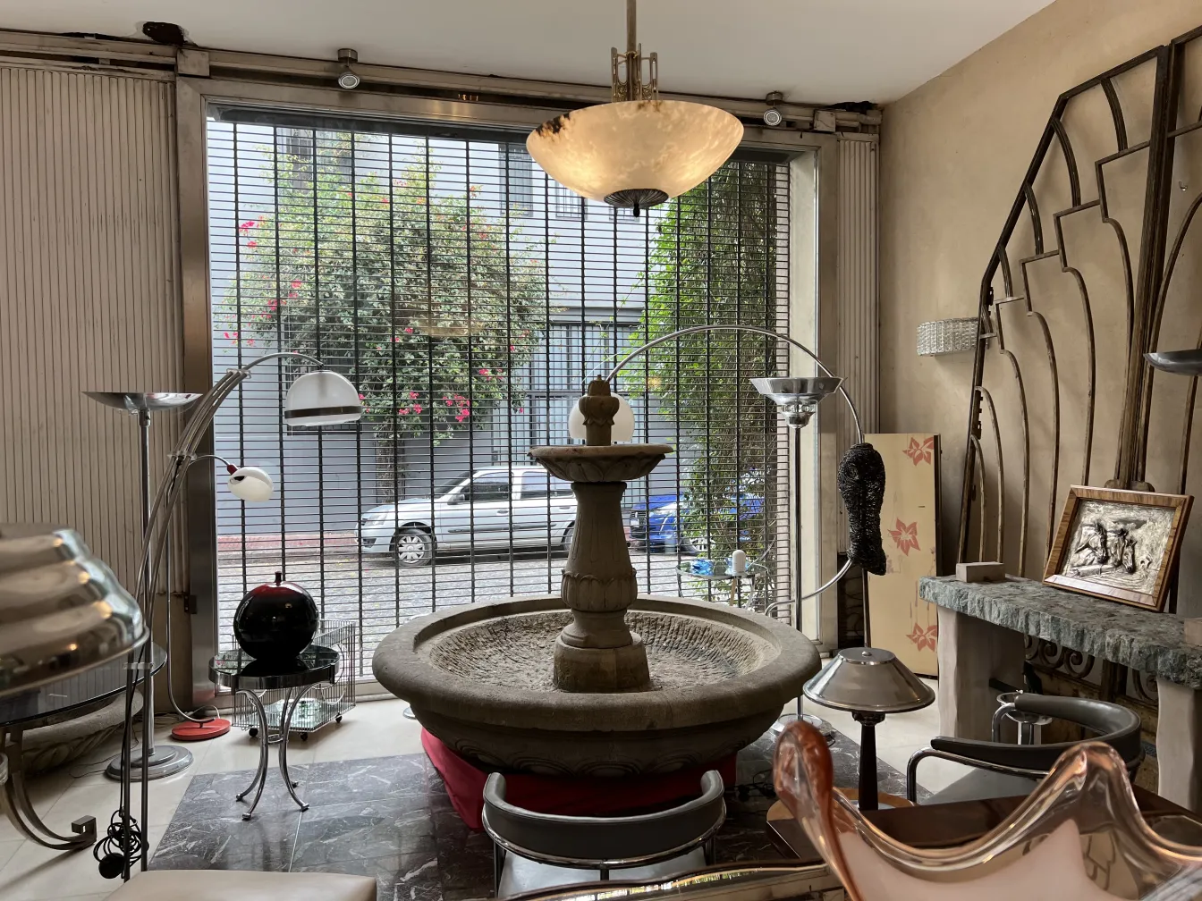 Lustre ancien éclairant une pièce avec une fontaine.