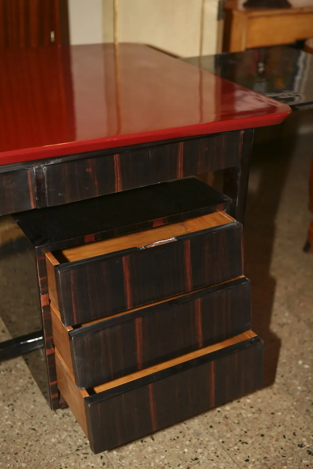 escritorio antiguo con superficie roja y tres tiradores