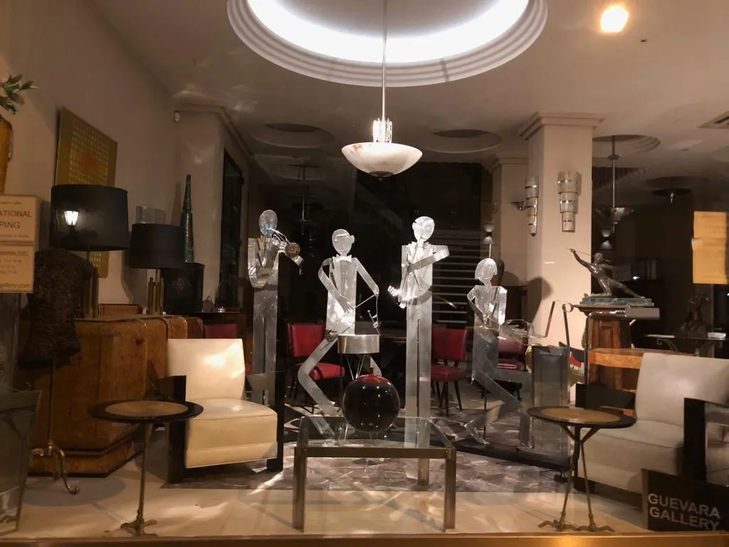 Lámpara de techo antigua con detalle elegante, ideal para decoración. Ambiente de galería con esculturas. 