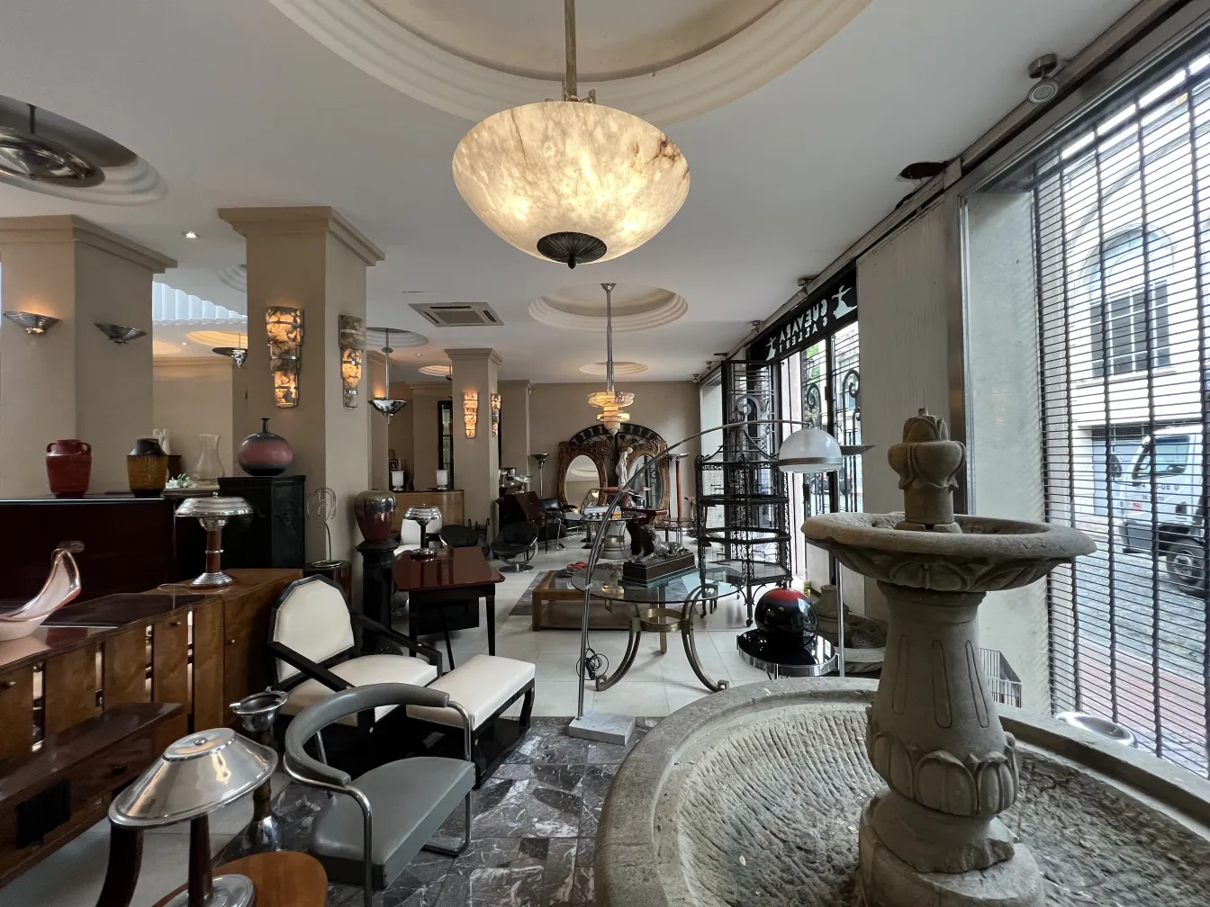 Lámpara de techo antigua con diseño elegante, iluminando el ambiente. Muebles vintage en el fondo.