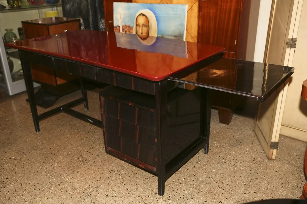 Bureau ancien avec surface rouge et côté noir dans un cadre classique.