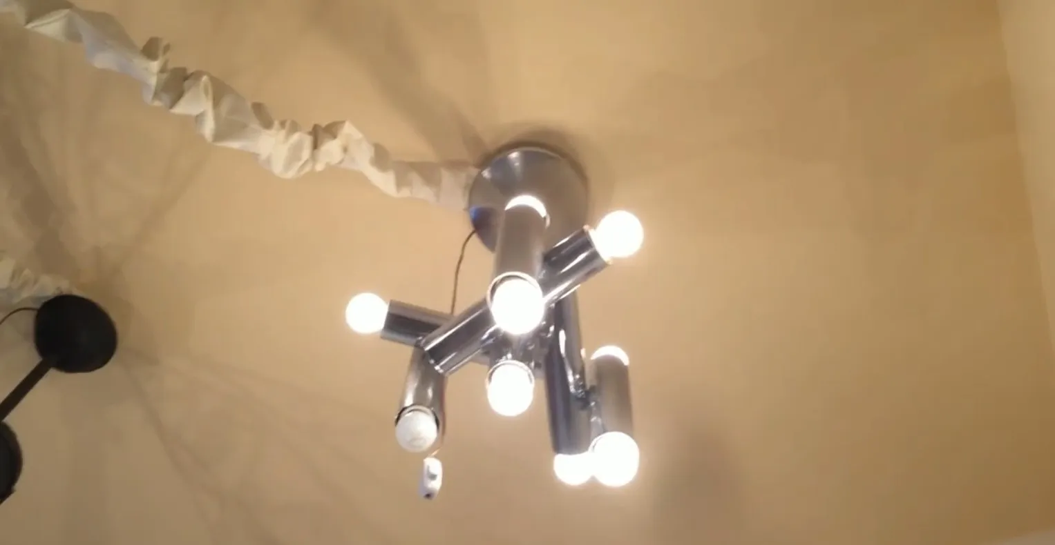 Lustre ancien avec plusieurs bras et lumières brillantes dans une ambiance accueillante.