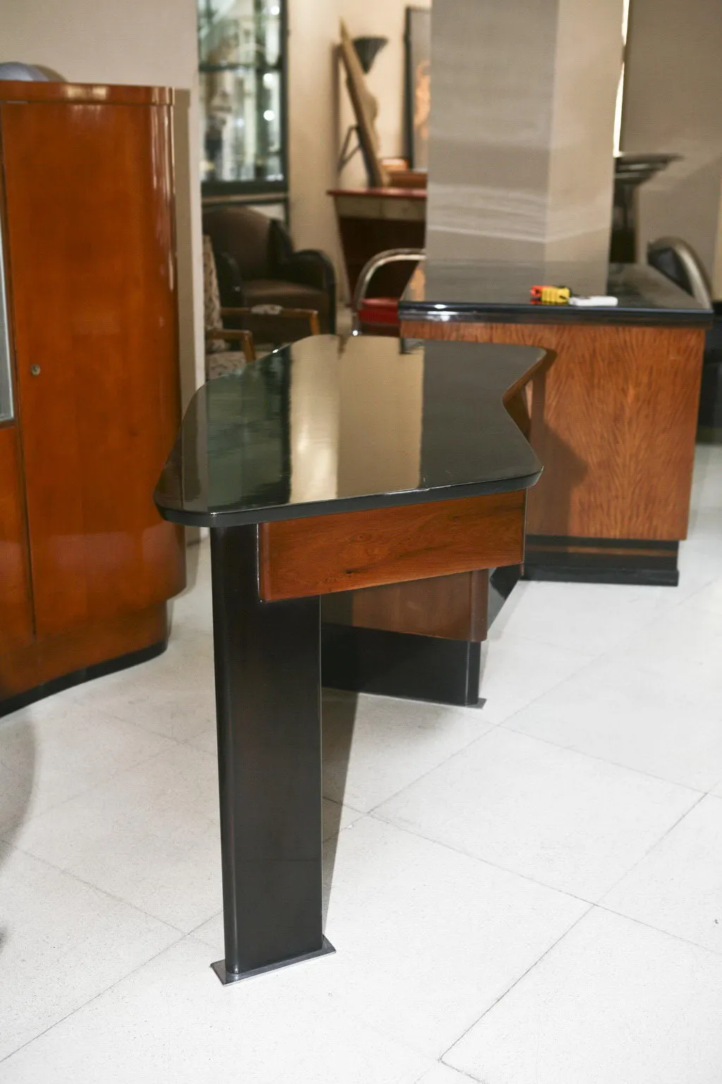 Escritorio antiguo con superficie negra, detalles de madera