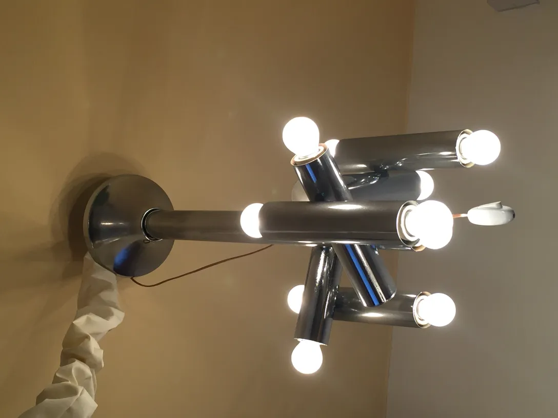 Lampada a sospensione antica con più lampadine che illuminano lo spazio.