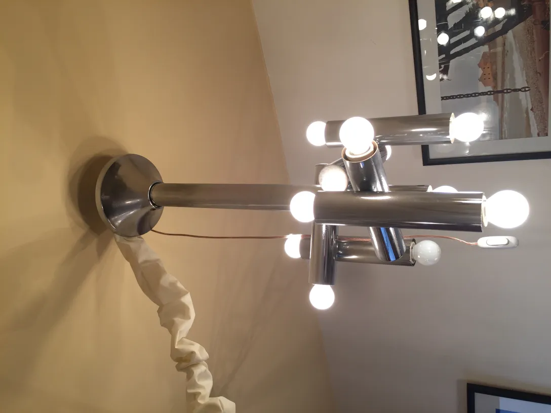 Lâmpada de teto antiga com várias luzes brilhantes em um design moderno, em um fundo claro.