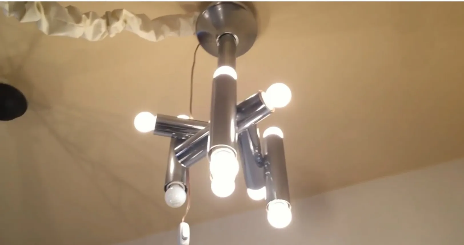 Antique hanging lamp with multiple light globes, in a modern setting.